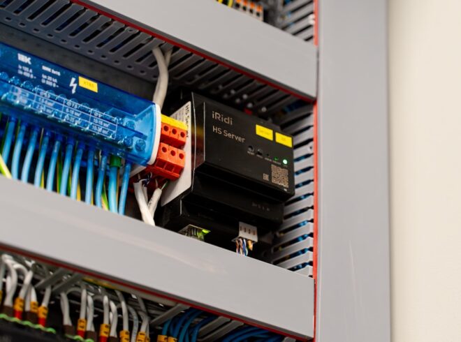 Electrical panel with wiring, circuit components, and an iRidi HS Server, illustrating commercial electrical code compliance and service capabilities.