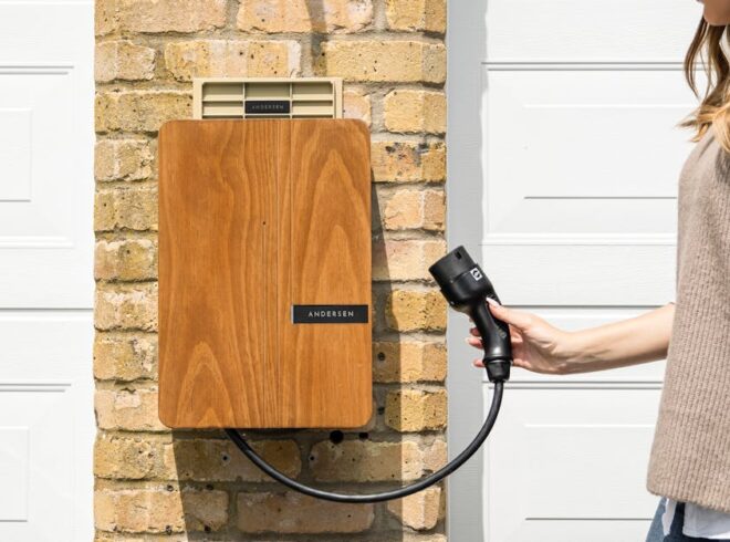 Woman connecting an EV charger to a wall-mounted charging unit, showcasing modern electric vehicle charging solutions relevant to home electrification in Torrance.